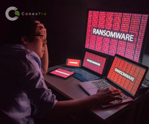 Person using a computer with ransomware in red text on screen